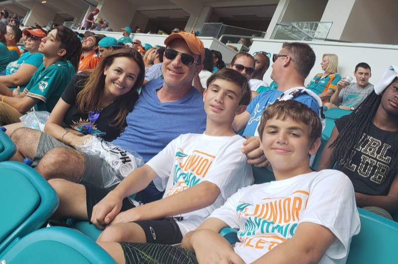 the family together at a football game, positive parenting tips